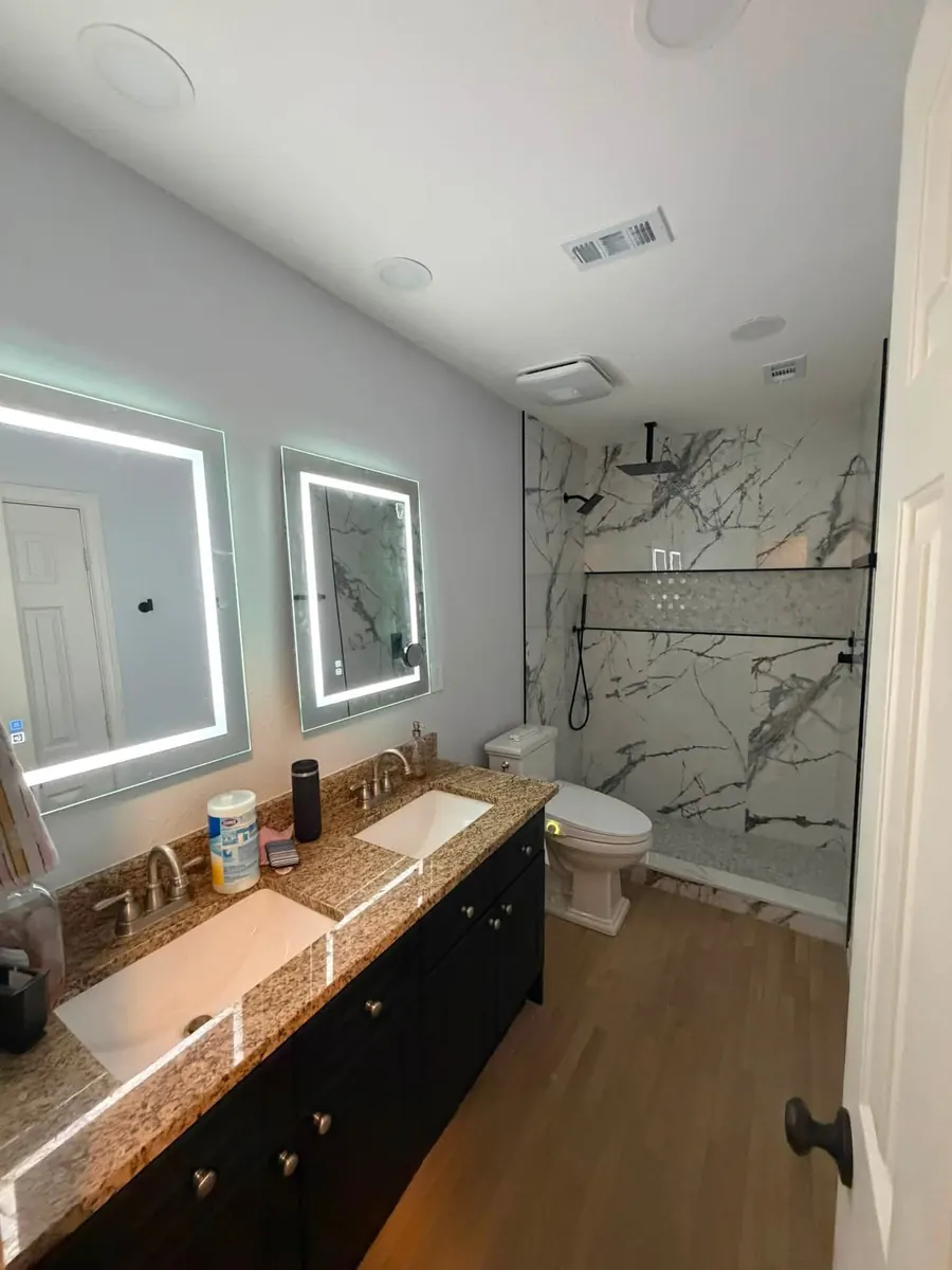 After: Guest bathroom remodel featuring a new marble-look porcelain tile shower
