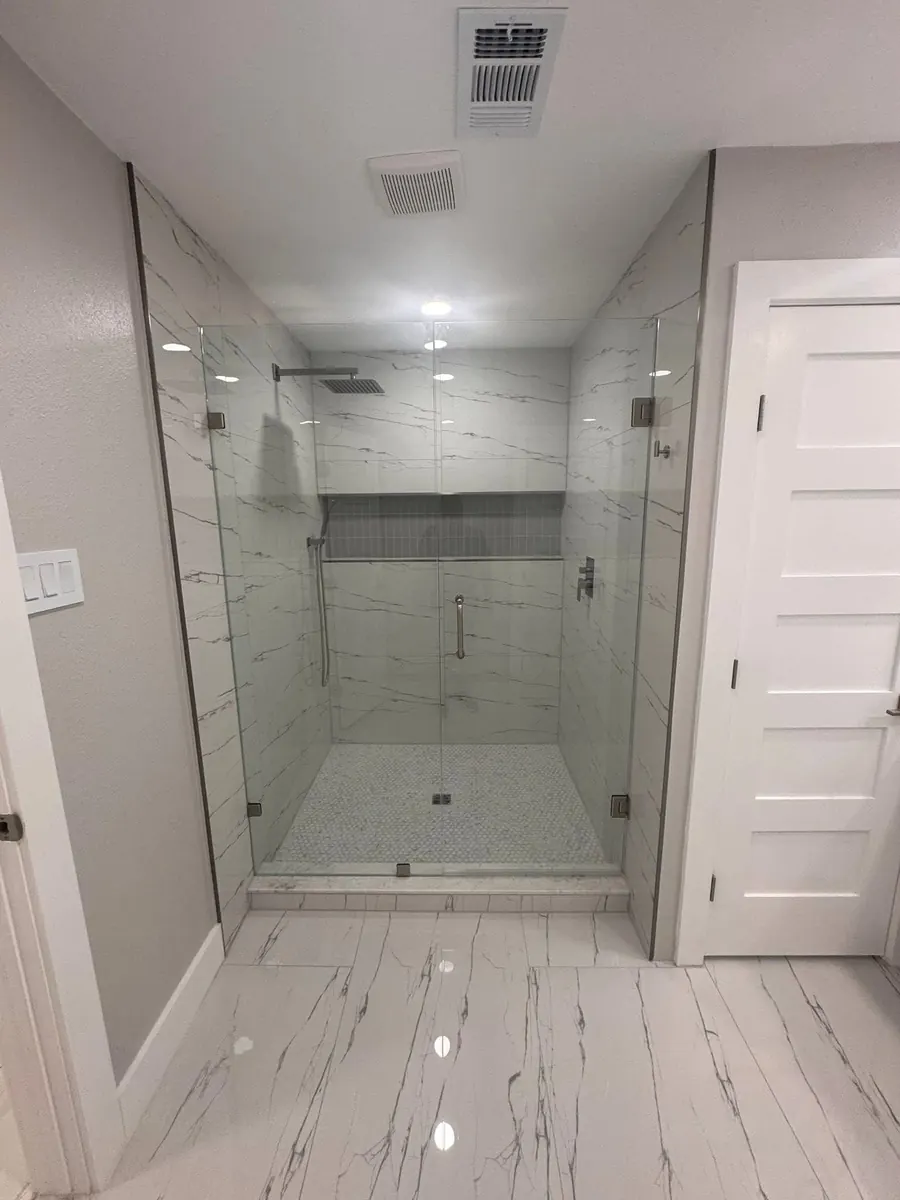 After: Bathroom transformation featuring a custom walk-in shower with a full-width built-in niche